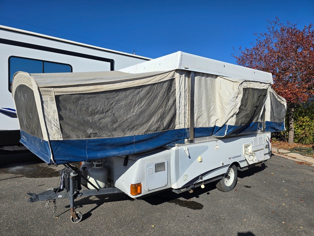 Interior seating area of a pre-owned 2005 Fleetwood RV Americana Victory pop up camper, highlighting the camper's spaciousness when expanded.