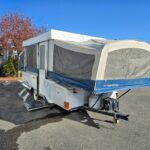 Exterior view of a used 2005 Fleetwood RV Americana Victory pop up camper, showcasing its compact and towable design.