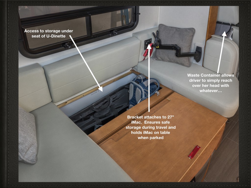 U-dinette area in a Unity travel van with under-seat storage access and a mounted iMac workstation.