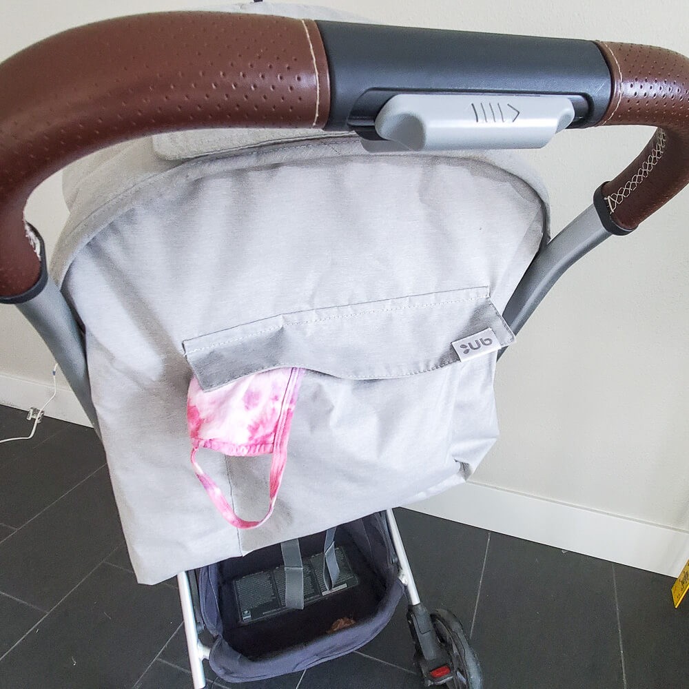 close up of back pocket on uppababy minu, full and with mask hanging out