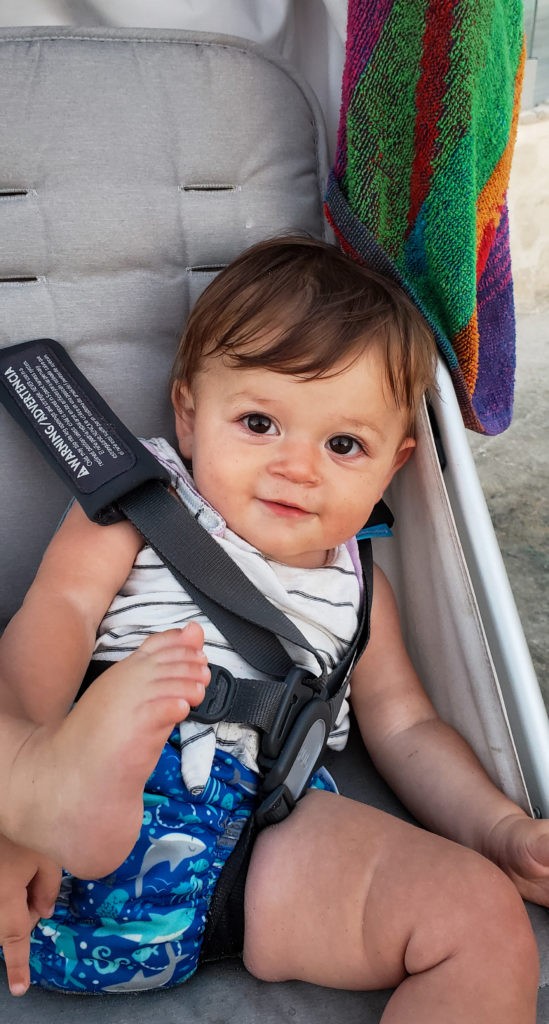 smiling baby slumped over in uppababy minu stroller