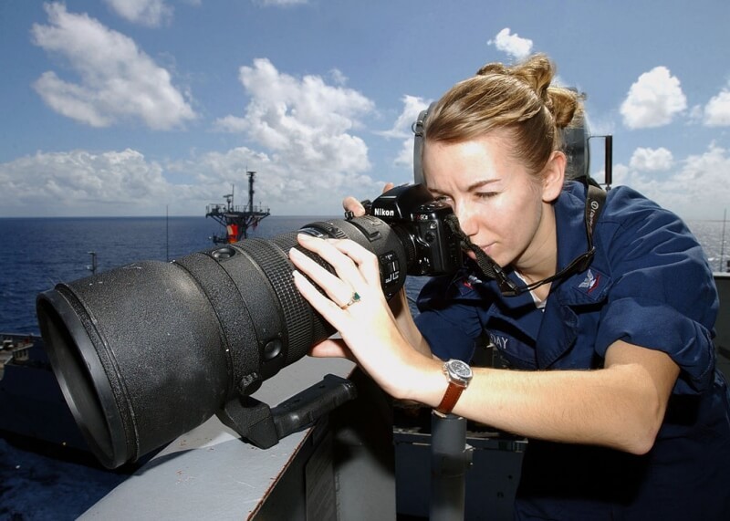 Image of a large telephoto lens on an aircraft carrier illustrating the impracticality of oversized lenses for travel