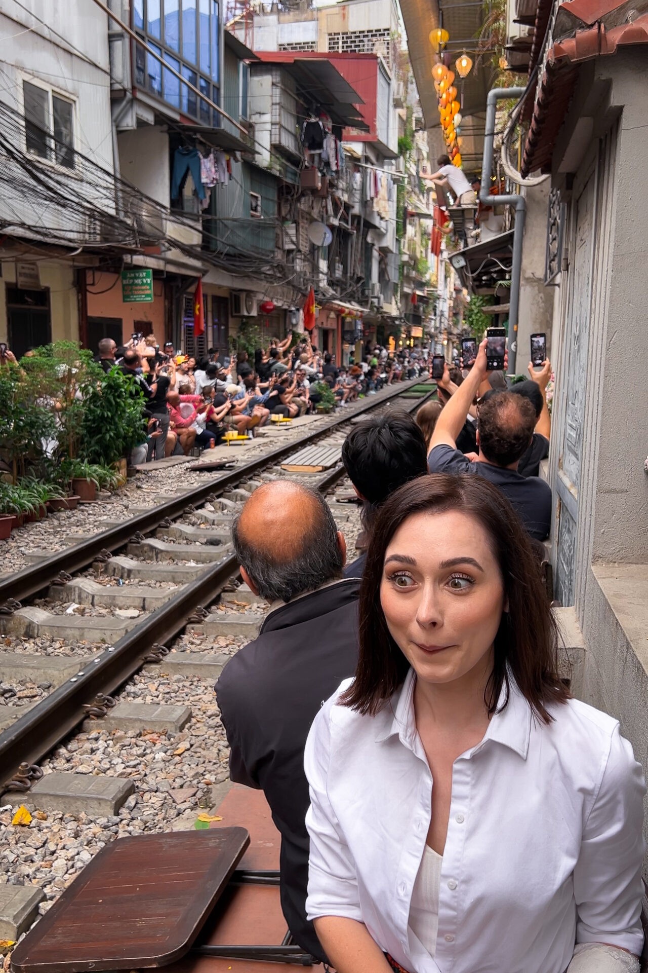 Travel blogger Jordan Gassner smiling in Hanoi Train Street, Vietnam, anticipating the train arrival - Vietnam travel blog 2024