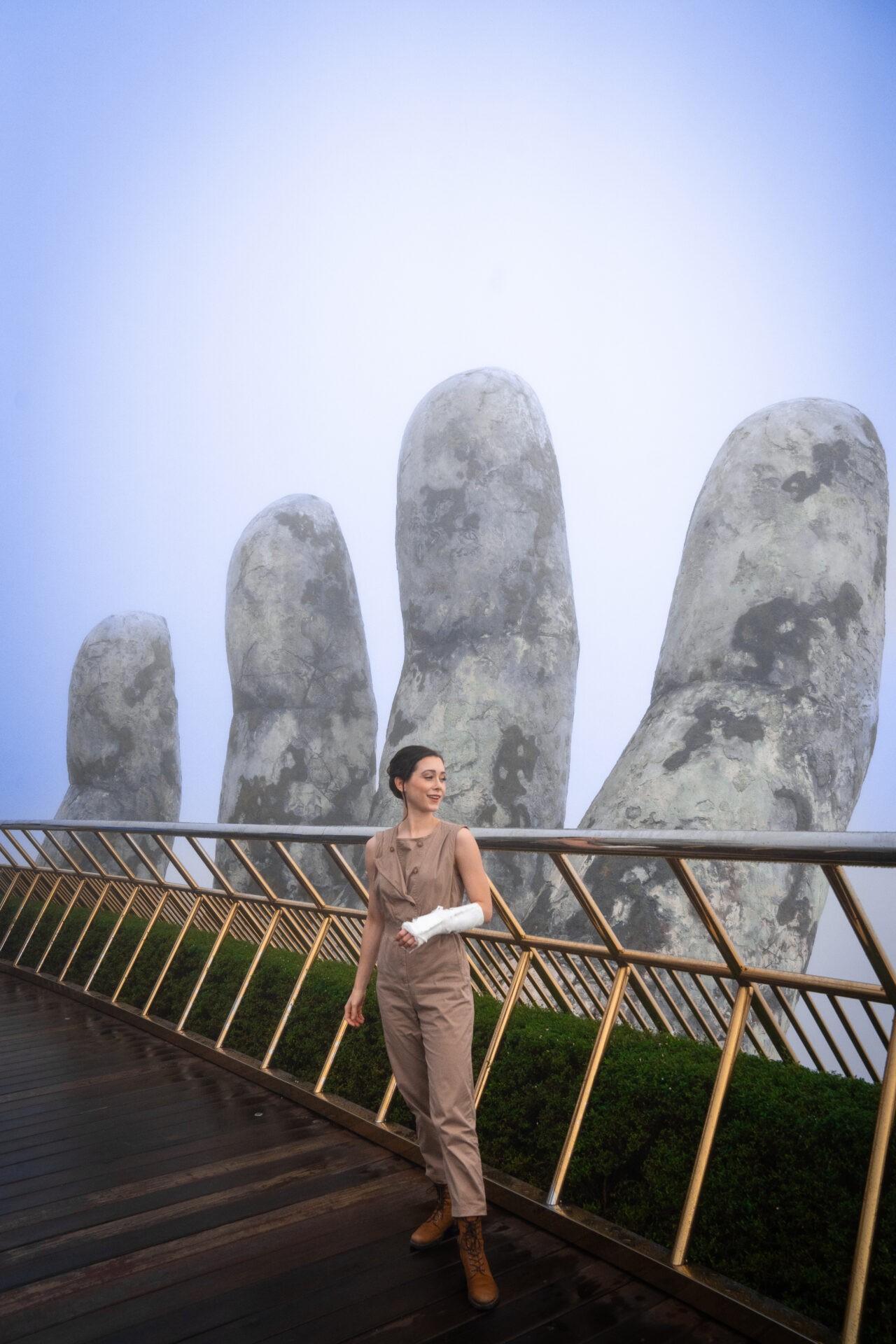 Travel blogger Jordan Gassner with a cast on her arm at the Golden Bridge in Ba Na Hills, Vietnam, visiting the iconic hand bridge despite injury - Vietnam travel blog 2024