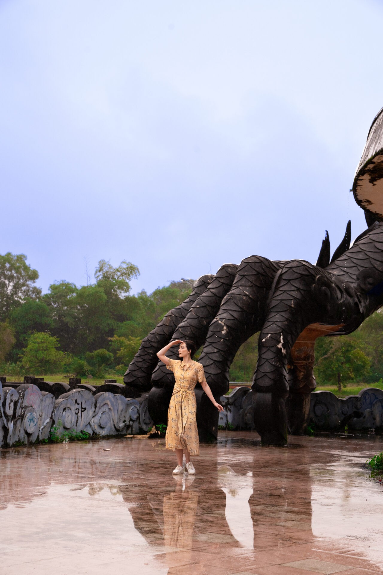 Travel blogger Jordan Gassner overlooking the abandoned Ho Thuy Thien Waterpark in Hue, Vietnam, featuring a giant dragon structure - Vietnam travel blog 2024