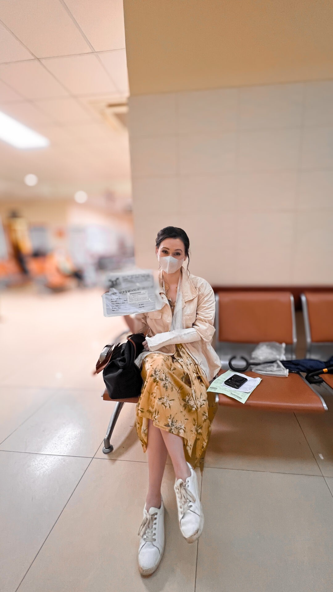 Travel blogger Jordan Gassner holding an X-ray in a Vietnamese hospital with a cast on her arm, experiencing healthcare in Vietnam as a traveler - Vietnam travel blog 2024