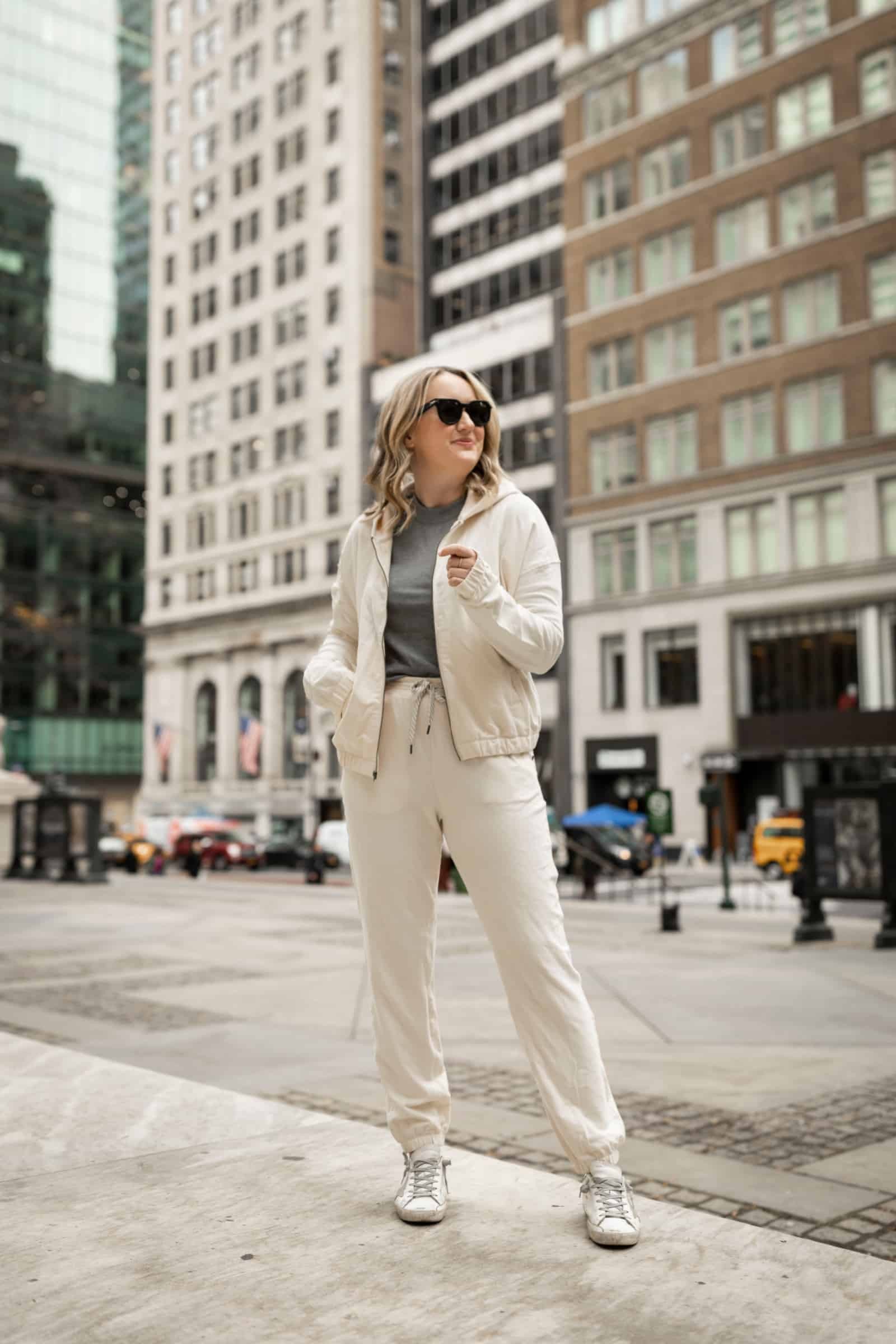 Woman wearing a Vuori lounge set, paired with a coatigan, as a comfortable and stylish travel outfit for a long flight.