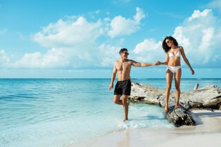 Travelers walking along a beach in Montego Bay, Jamaica, embodying the spirit of peregrination