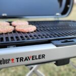 Weber Traveler grill with burger patties cooking on the grill grates