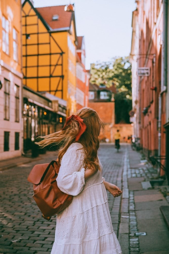 Woman wearing Lo &amp; Sons Bond Sling in an urban outdoor setting