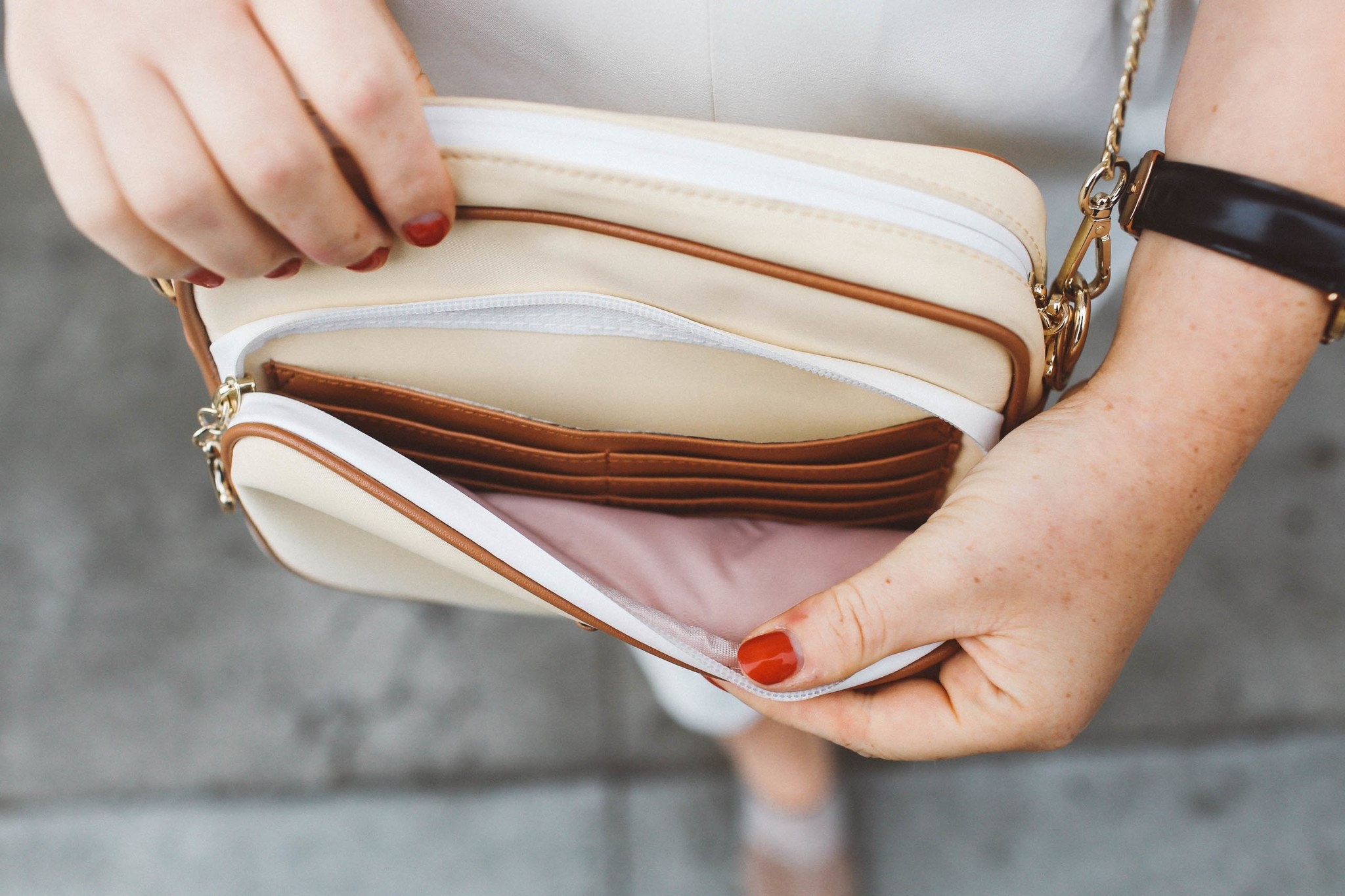 Woman with cream Arden Cove crossbody bag in urban setting