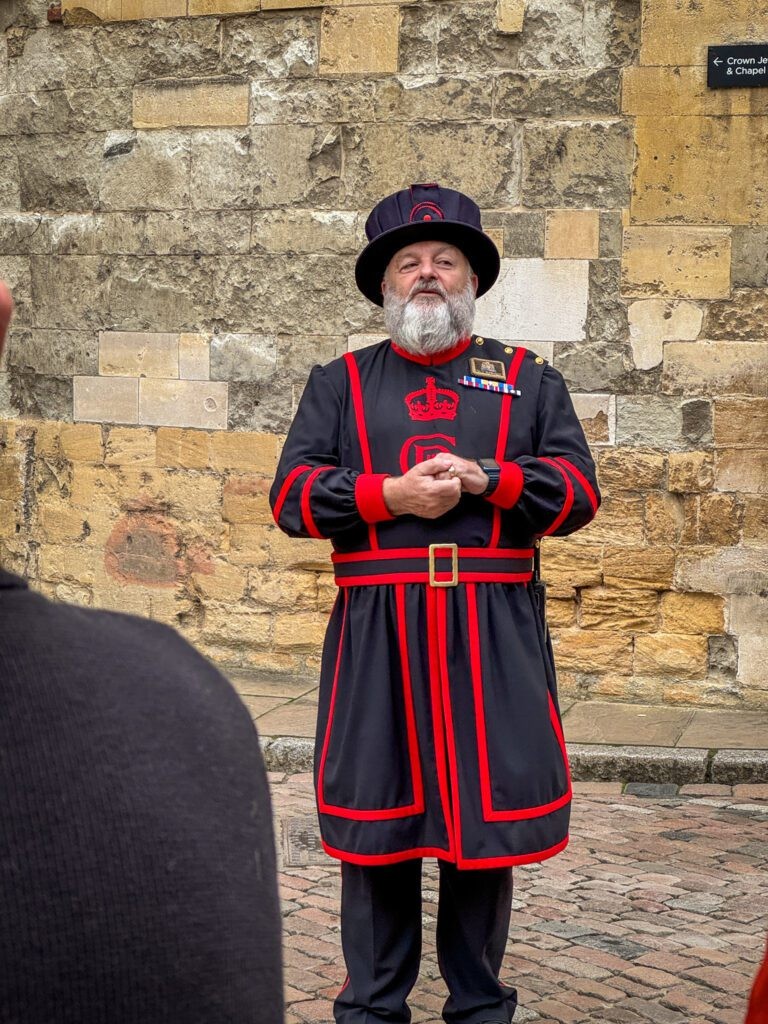 A Yeoman Warder (Beefeater) in his iconic uniform at the Tower of London, standing guard with a halberd