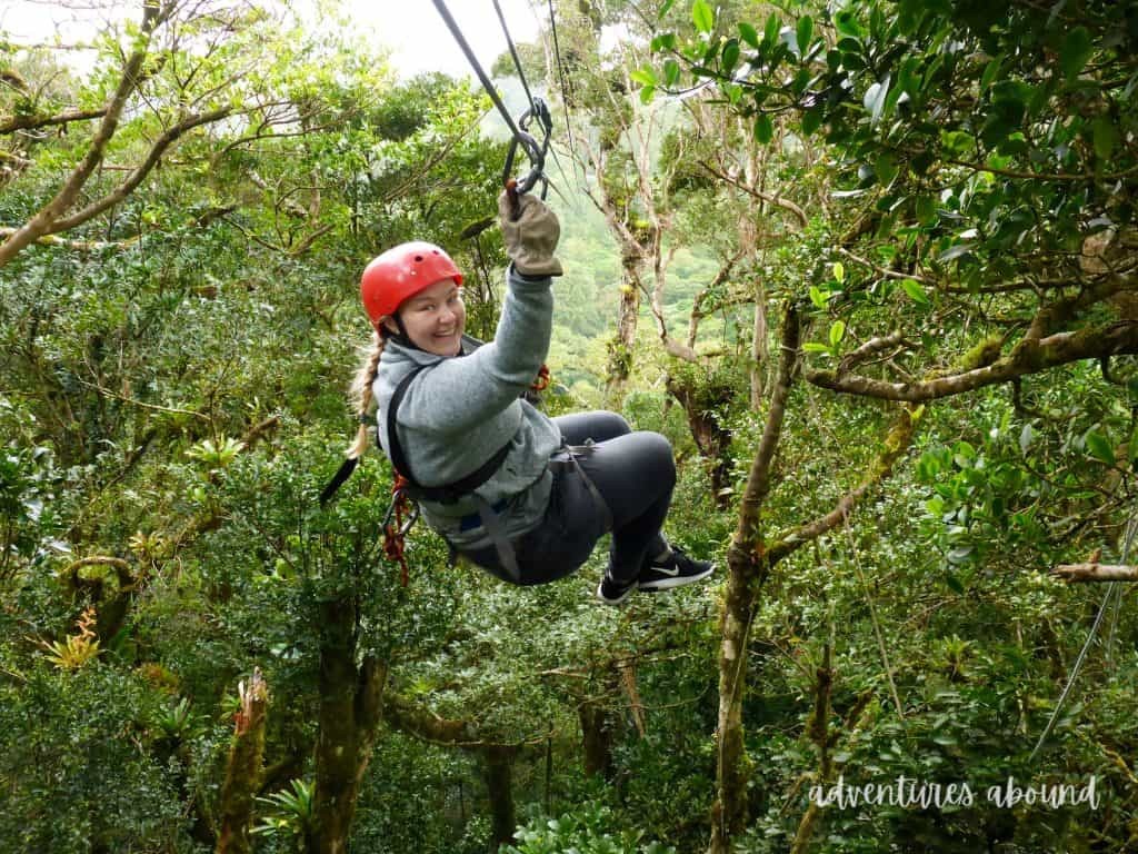 A girl wearing a red helmet and ziplining during a trip to Costa Rica.