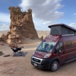 A cozy interior of a Winnebago Solis campervan, showcasing the sleeping area and natural light.