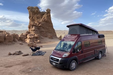 A cozy interior of a Winnebago Solis campervan, showcasing the sleeping area and natural light.