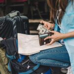 Woman traveller with a backpack counting cash she