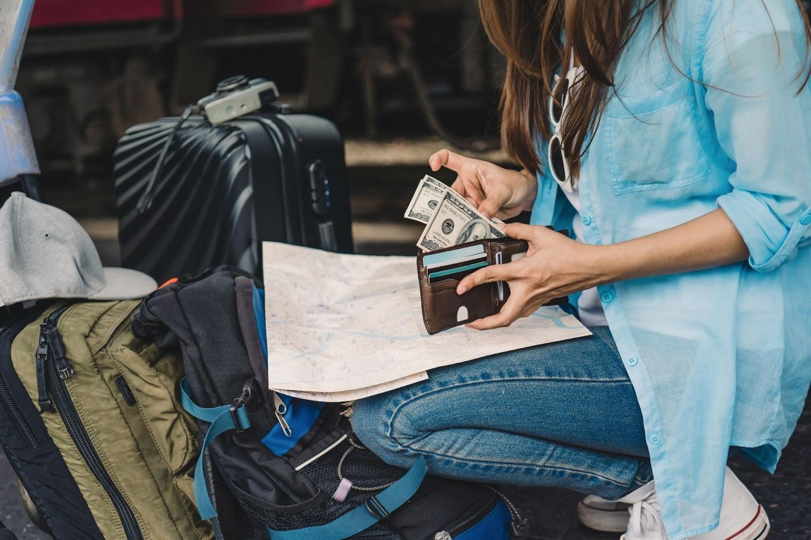 Woman traveller with a backpack counting cash she
