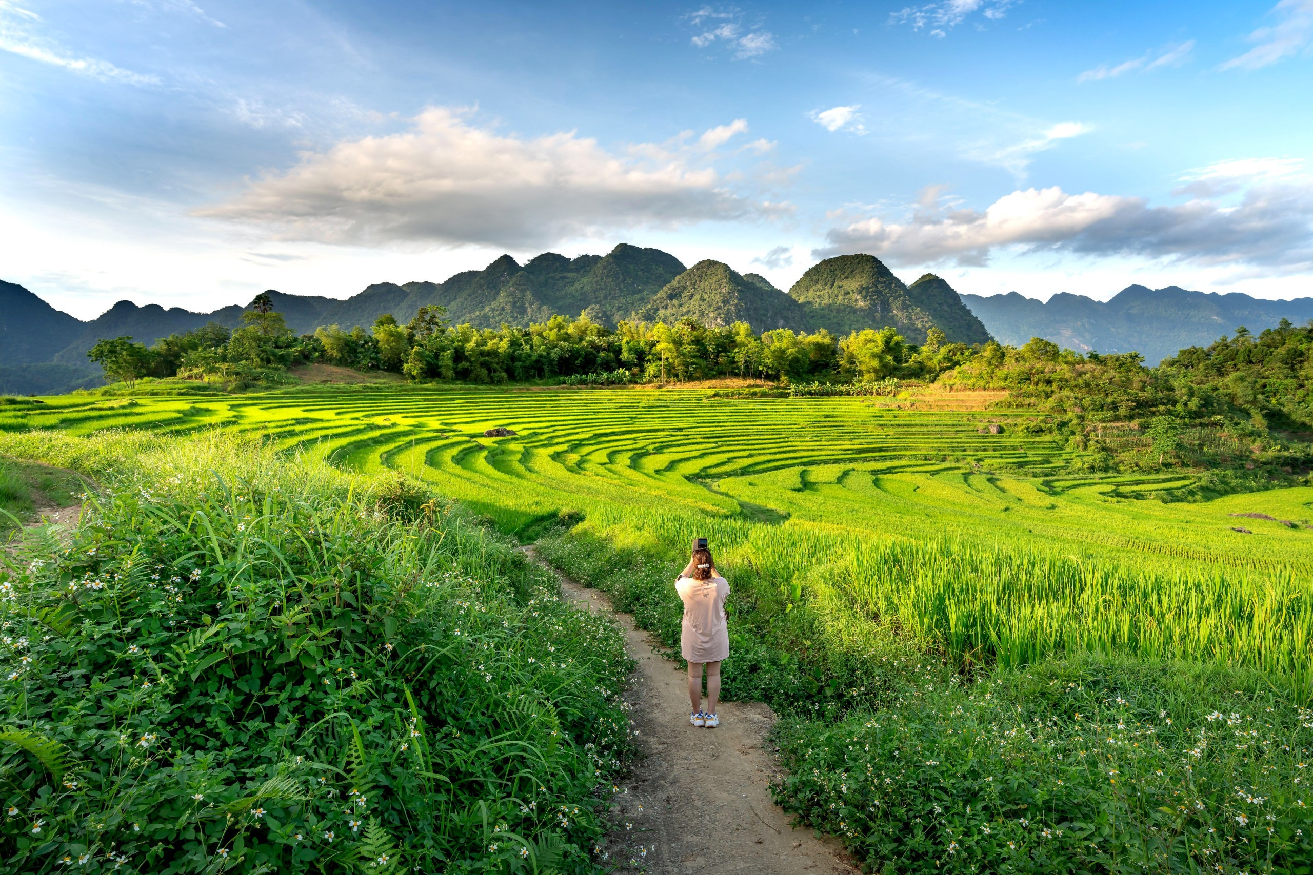 A visitor takes a photo in the terraces of Pu Luong