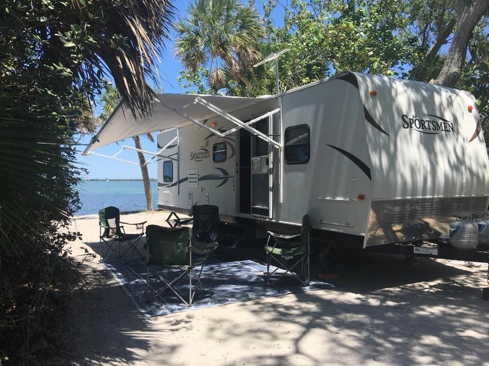 A cozy interior of a rental travel trailer with a comfortable bed and warm lighting, perfect for a relaxing road trip.