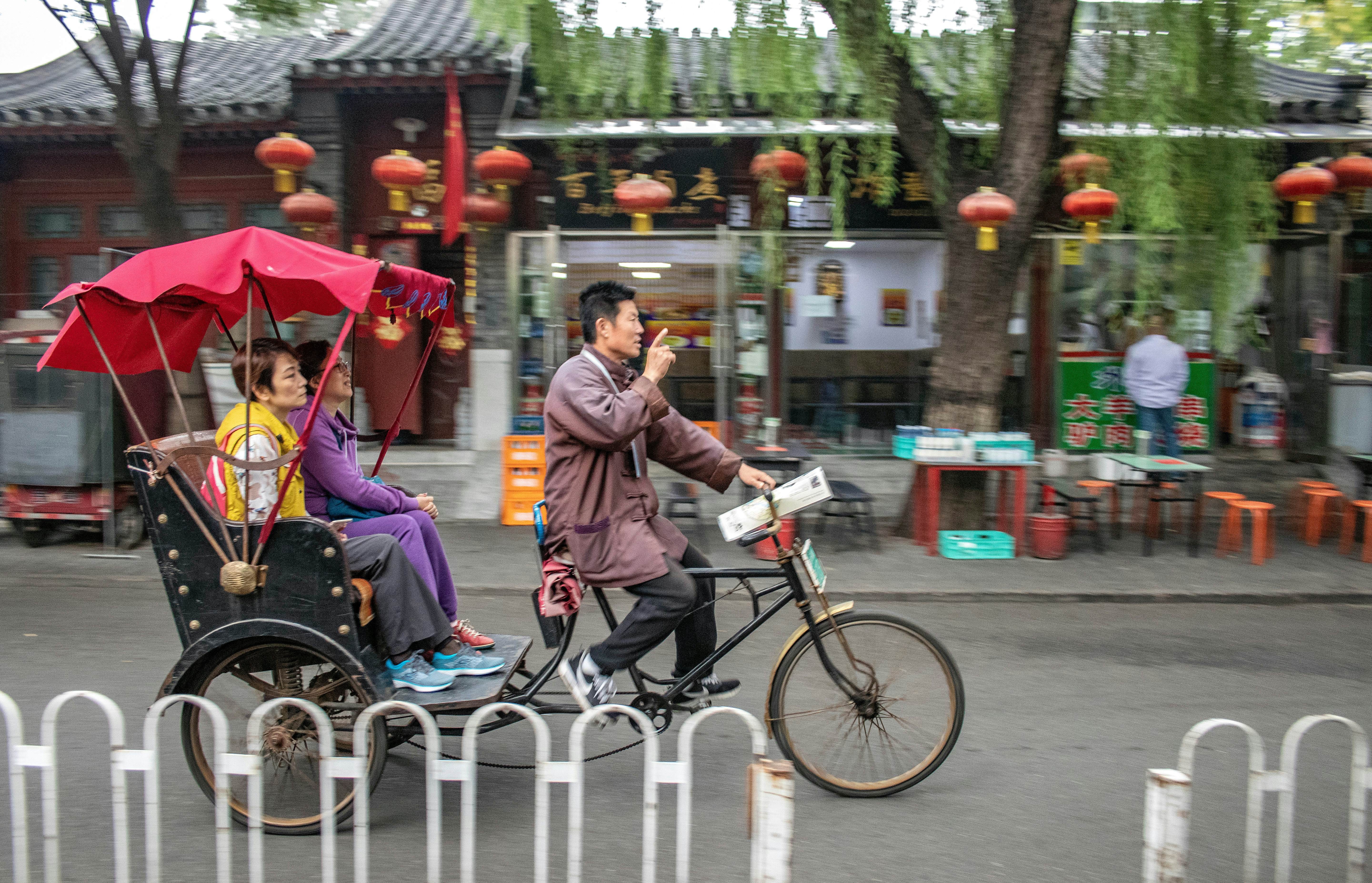 A rickshaw transporting tourists in a Beijing hutong, offering a unique local experience