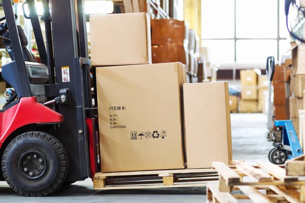 A forklift with a pallet and the mast tilted back slightly