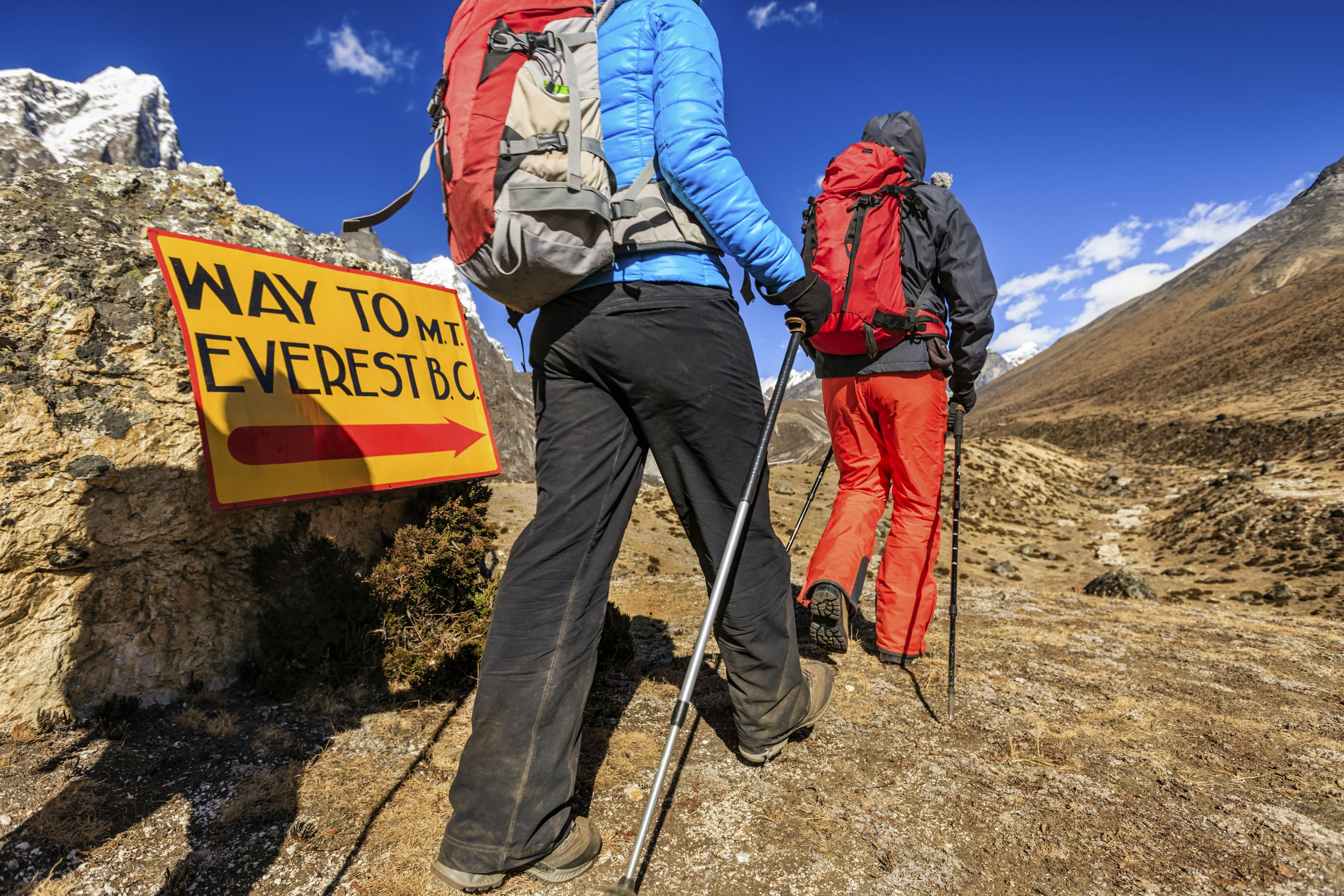 Trekkers on the way to Mount Everest Base Camp passing a signpost