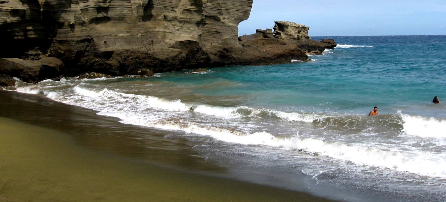 Ocean waves crashing on the shore with a clear blue sky above
