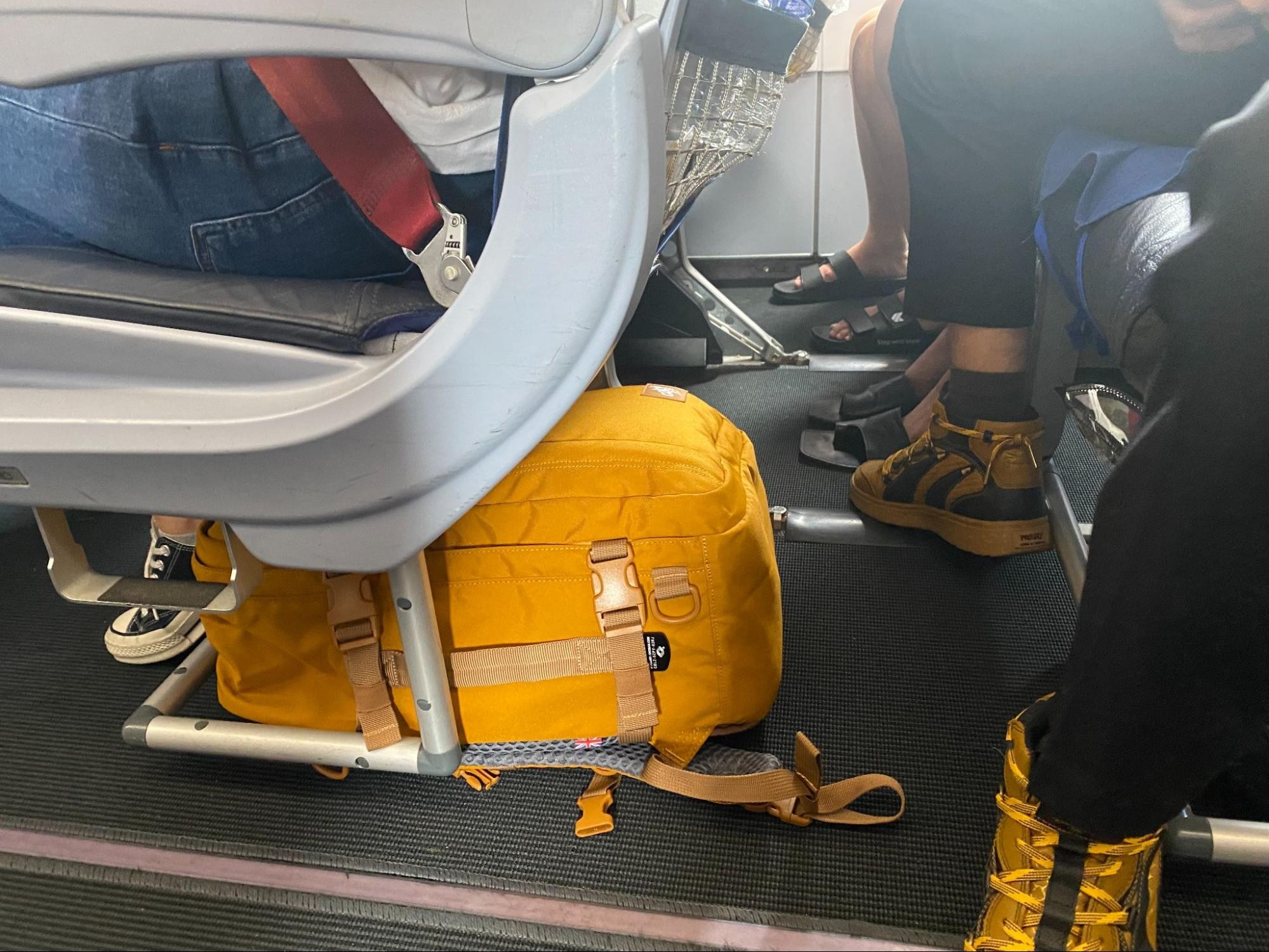 Woman placing a small bag under the airplane seat