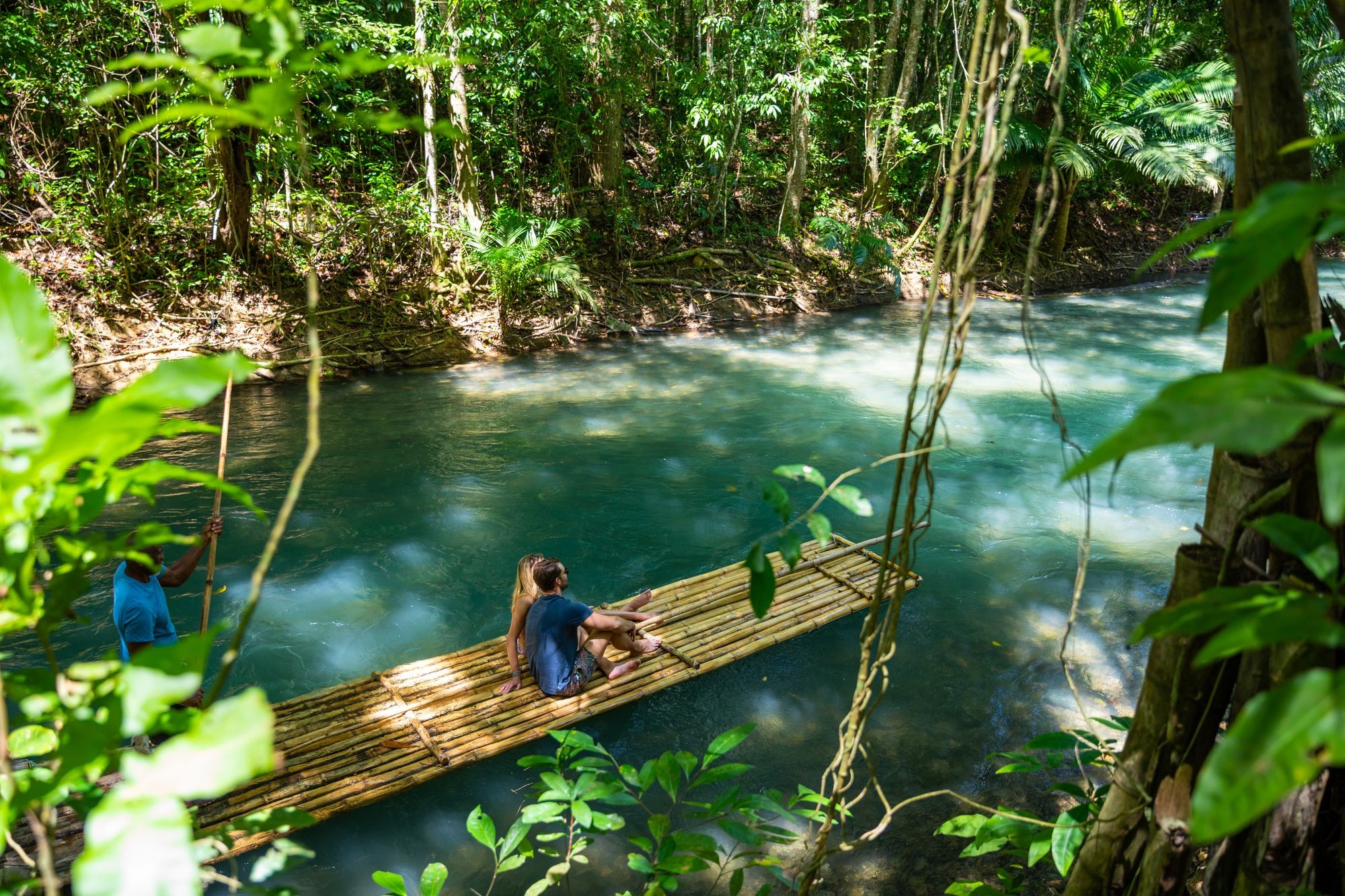 People rafting on the Martha Brea River in Jamaica surrounded by lush greenery