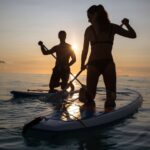 Couple enjoying the sunset on a Jamaican beach with calm, blue waters