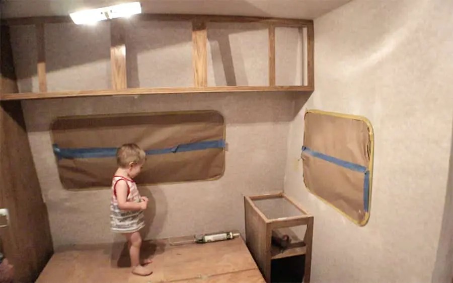 A travel trailer undergoing demolition, showing the removal of old cabinets and fixtures to prepare for remodeling