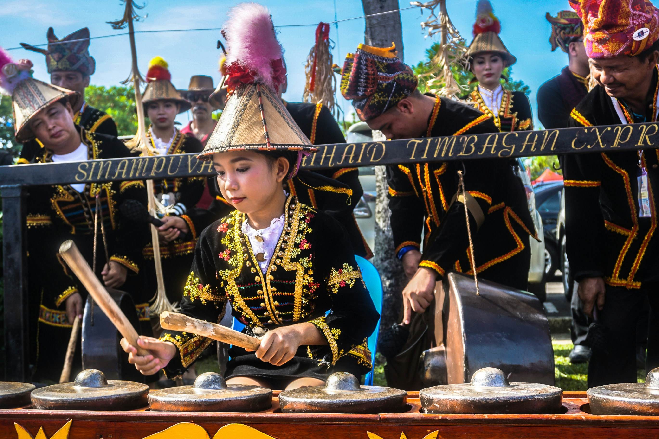 Kadazandusun girl playing a gong at the Sabah Harvest Festival, showcasing cultural richness