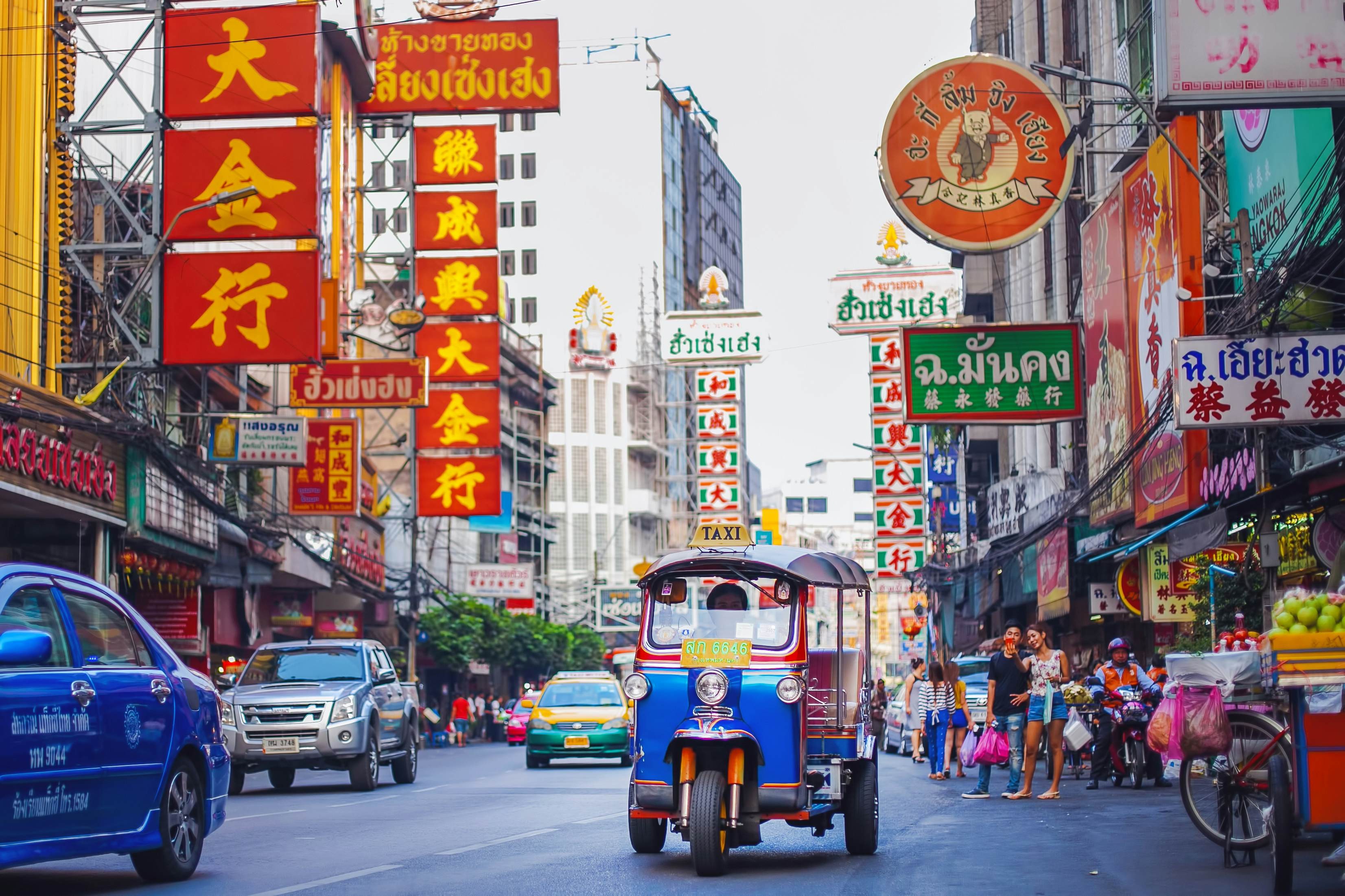 A vibrant scene of a Thai street with tuk-tuks, capturing the essence of local transport and culture