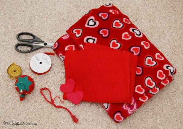 Layering fabrics for travel blanket creation, ensuring smooth alignment before pinning
