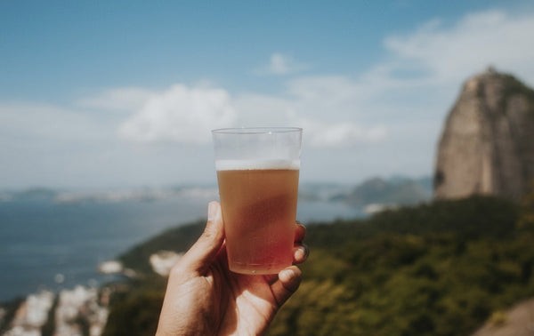 A bartender joyfully serving drinks against the backdrop of a stunning cityscape, symbolizing the exciting and varied life of a traveling bartender