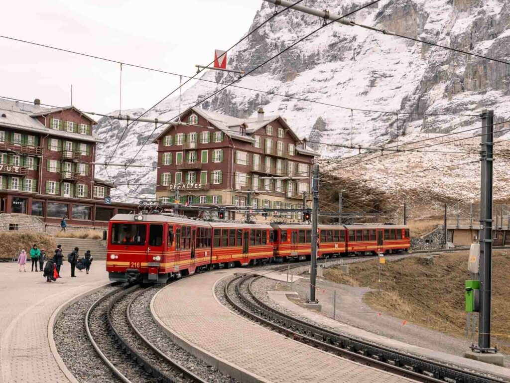A cogwheel train ascending Mount Pilatus, set against a backdrop of lush alpine meadows, highlighting the unique travel experiences available during a ten day Switzerland itinerary