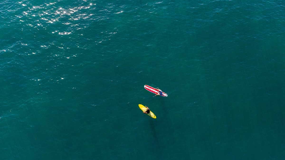 Two people surfing on surf boards in water