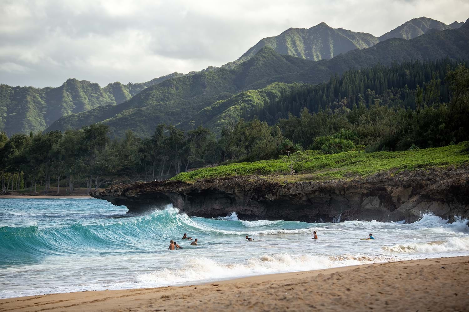 Couple enjoying a sunset view on a Hawaiian beach, embodying the romantic getaway experience