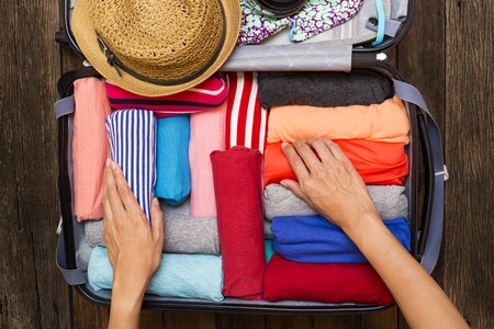Woman packing clothes into a suitcase for her trip