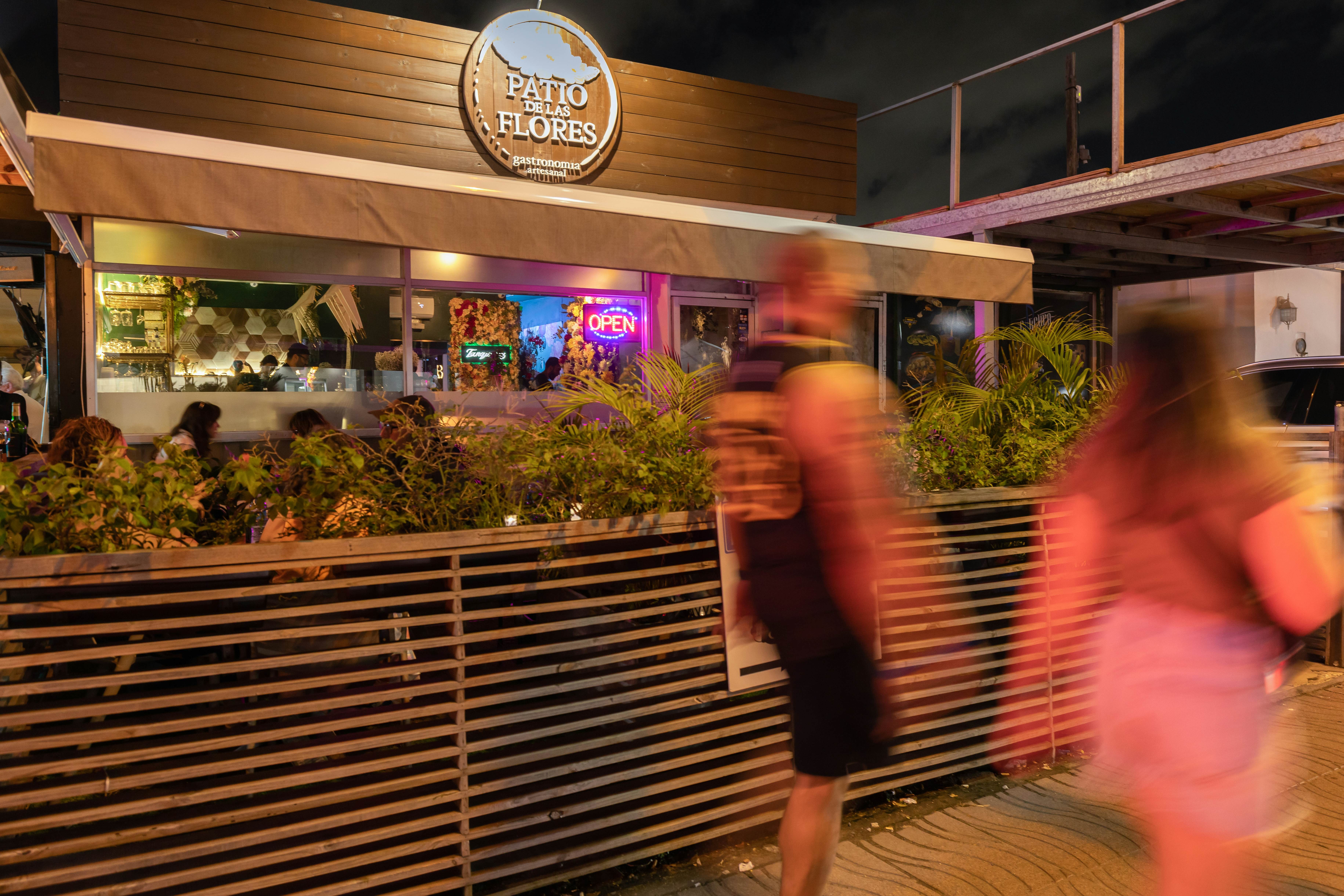Blurred people walking past a cocktail bar in San Juan
