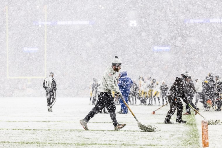 Grounds crew shoveling snow at Huntington Bank Field Stadium in Cleveland