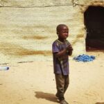 Local life in Timbuktu, with children and traditional architecture providing a glimpse into the cultural richness and everyday routines of the city.