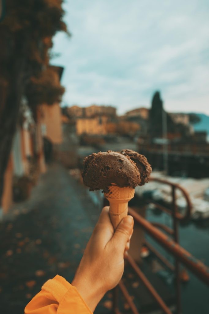 Scenic Italian street with a Vespa parked in front of a local trattoria, showcasing the charm of budget-friendly travel in Italy