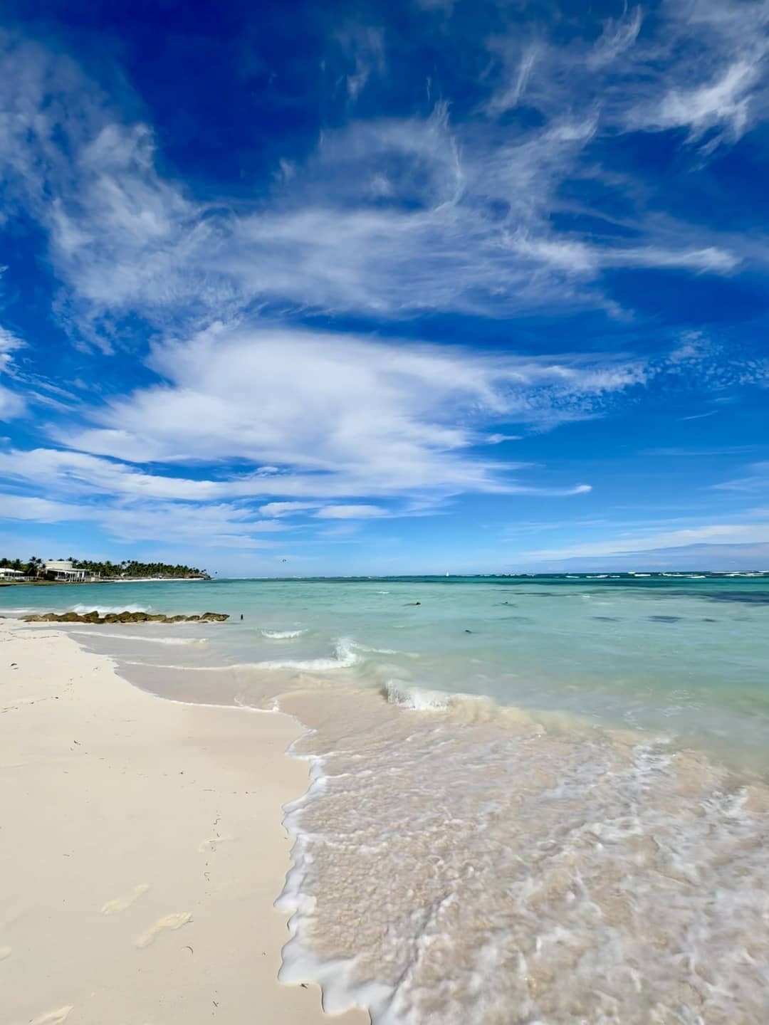 Scenic view of Playa Blanca, Punta Cana, with clear turquoise waters meeting the pristine white sand beach