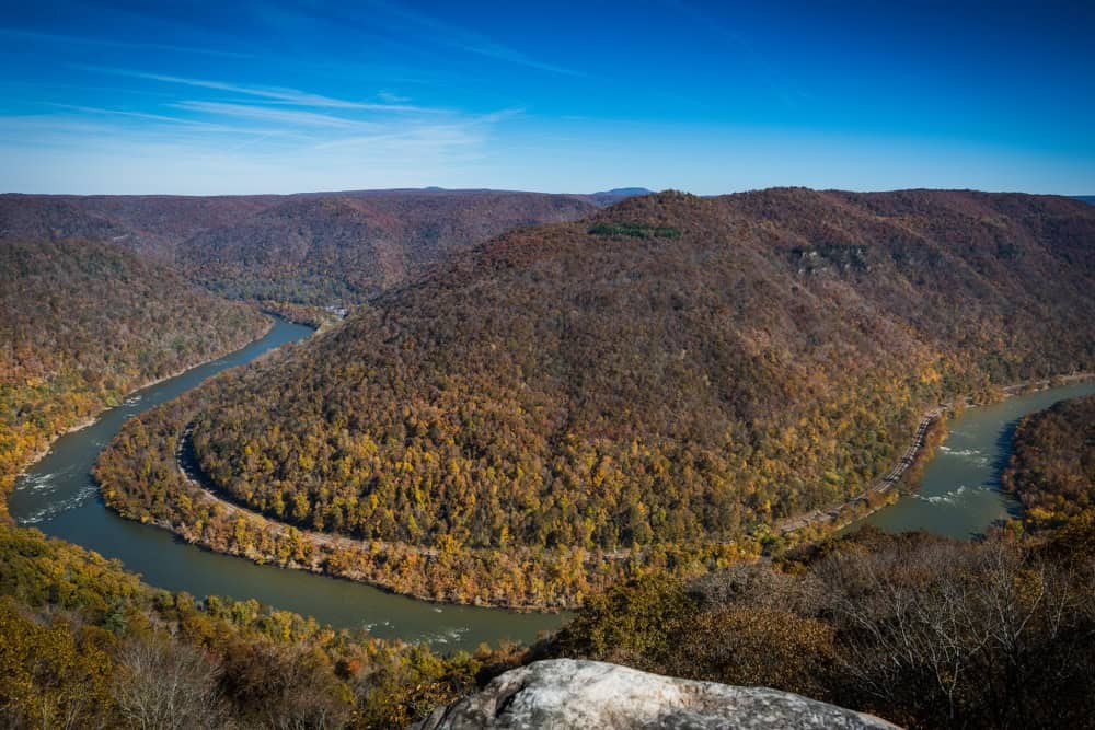 A scenic overlook in Beavers Bend Park shows a forested landscape under a clear sky.
