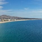 Cabo San Lucas coastline during the day, showcasing clear blue water and sandy beaches