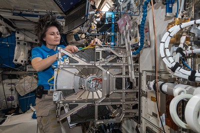 Astronaut Jessica Watkins and Bob Hines collaborate on a plant experiment aimed at sustaining crews on long missions, highlighting space's unique environment for scientific research, which includes equipment within the space station.