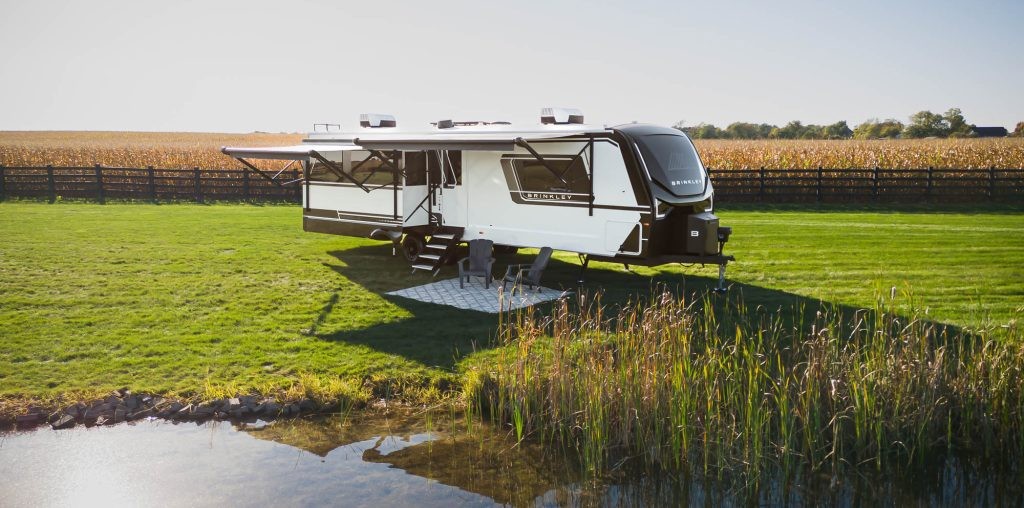Brinkley RV Travel trailer set up by a pond