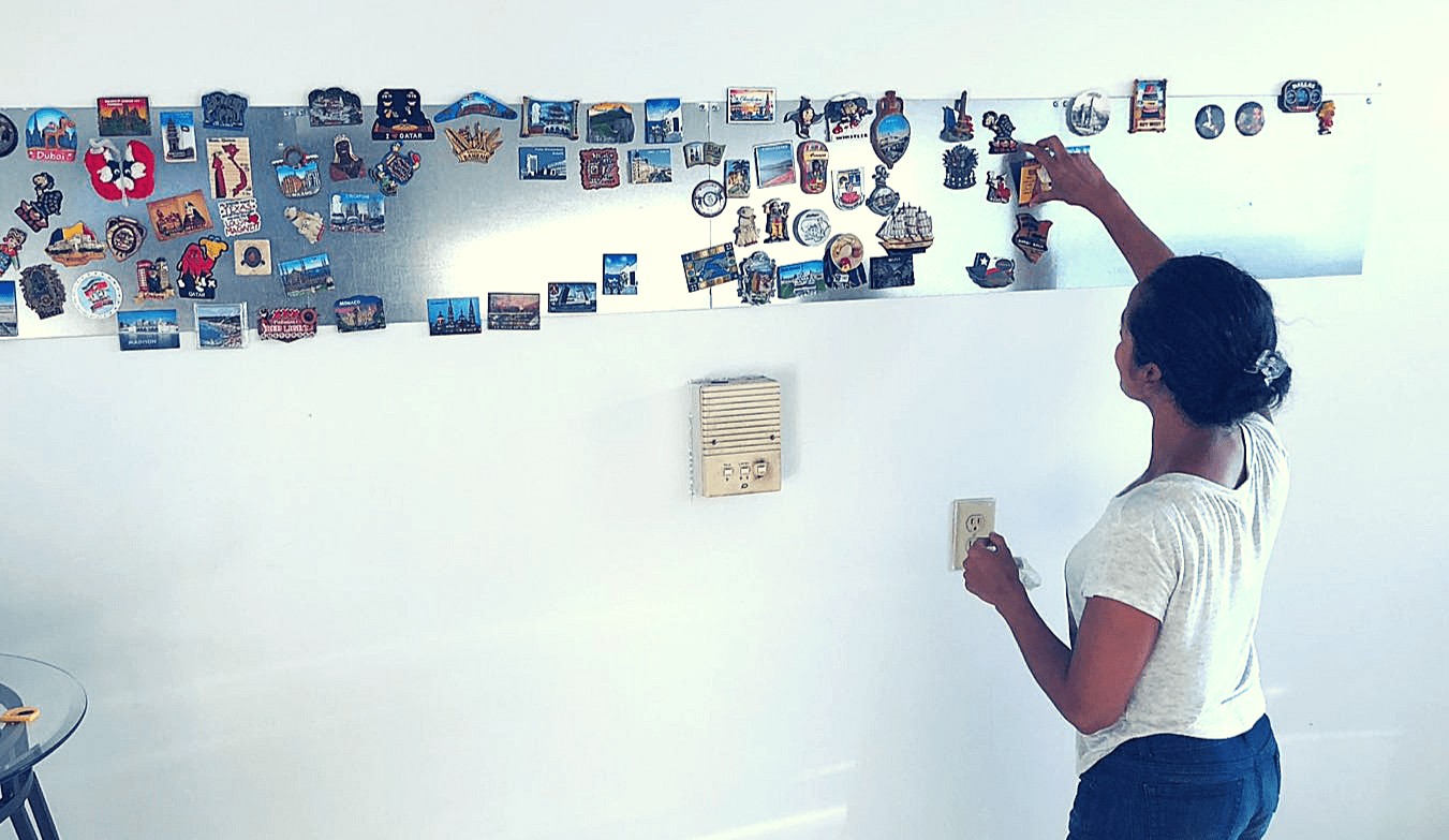 Magnets displayed on a large magnetic board in a kitchen, adding a colorful contrast to the room's decor.