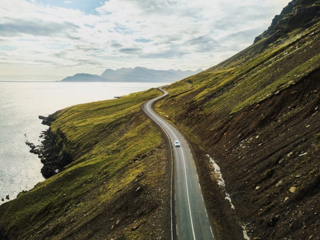Car driving along Iceland coast: freedom to explore wherever, whenever